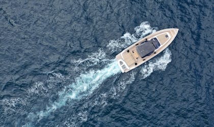 Dronebilde av fritidsbåt i fart på åpent hav 